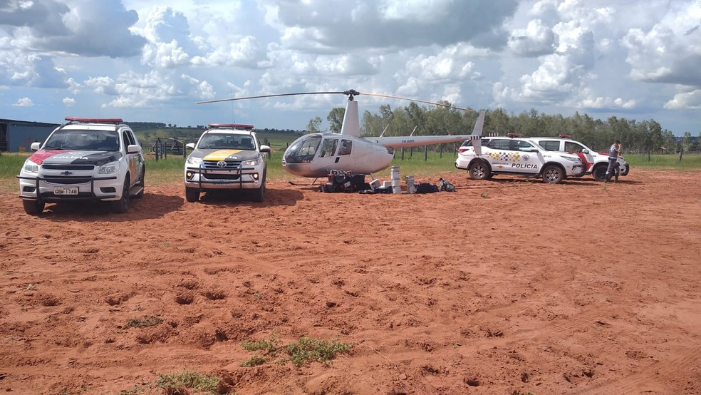 Helicóptero cercado por viaturas; droga saiu da fronteira com MS (Imagem: Divulgação)